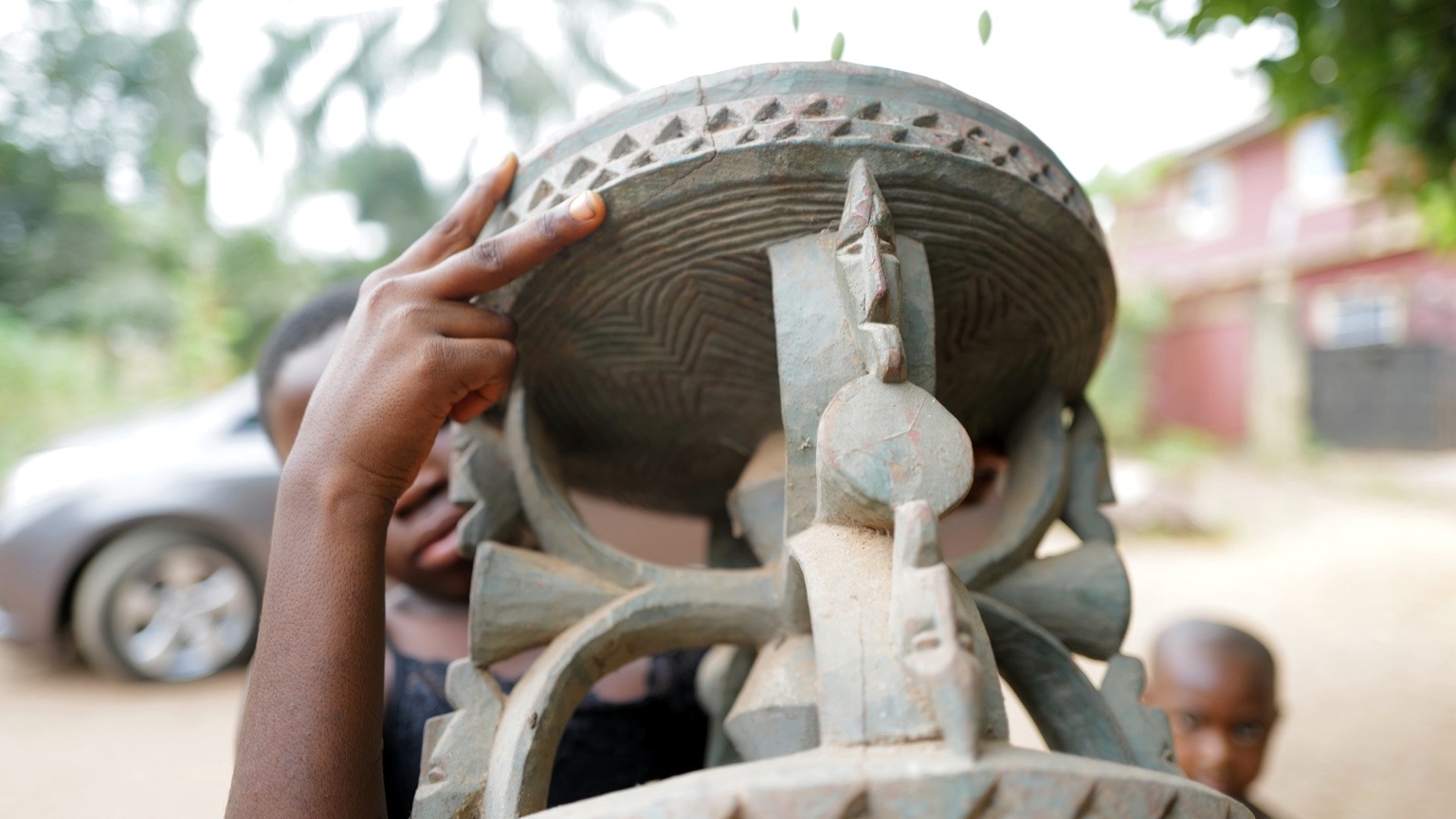Hands holding a carved object to reveal its form and markings