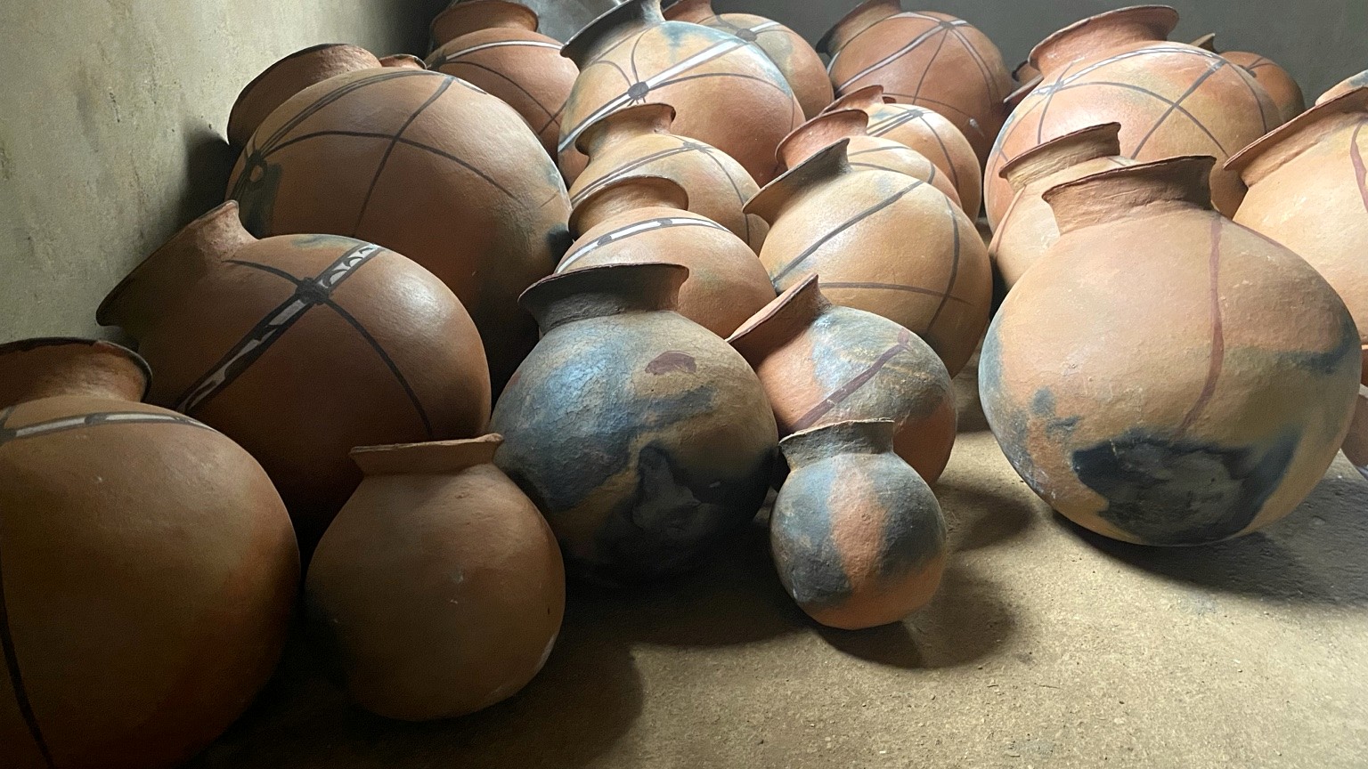 A closely gathered collection of hand-formed earthen vessels