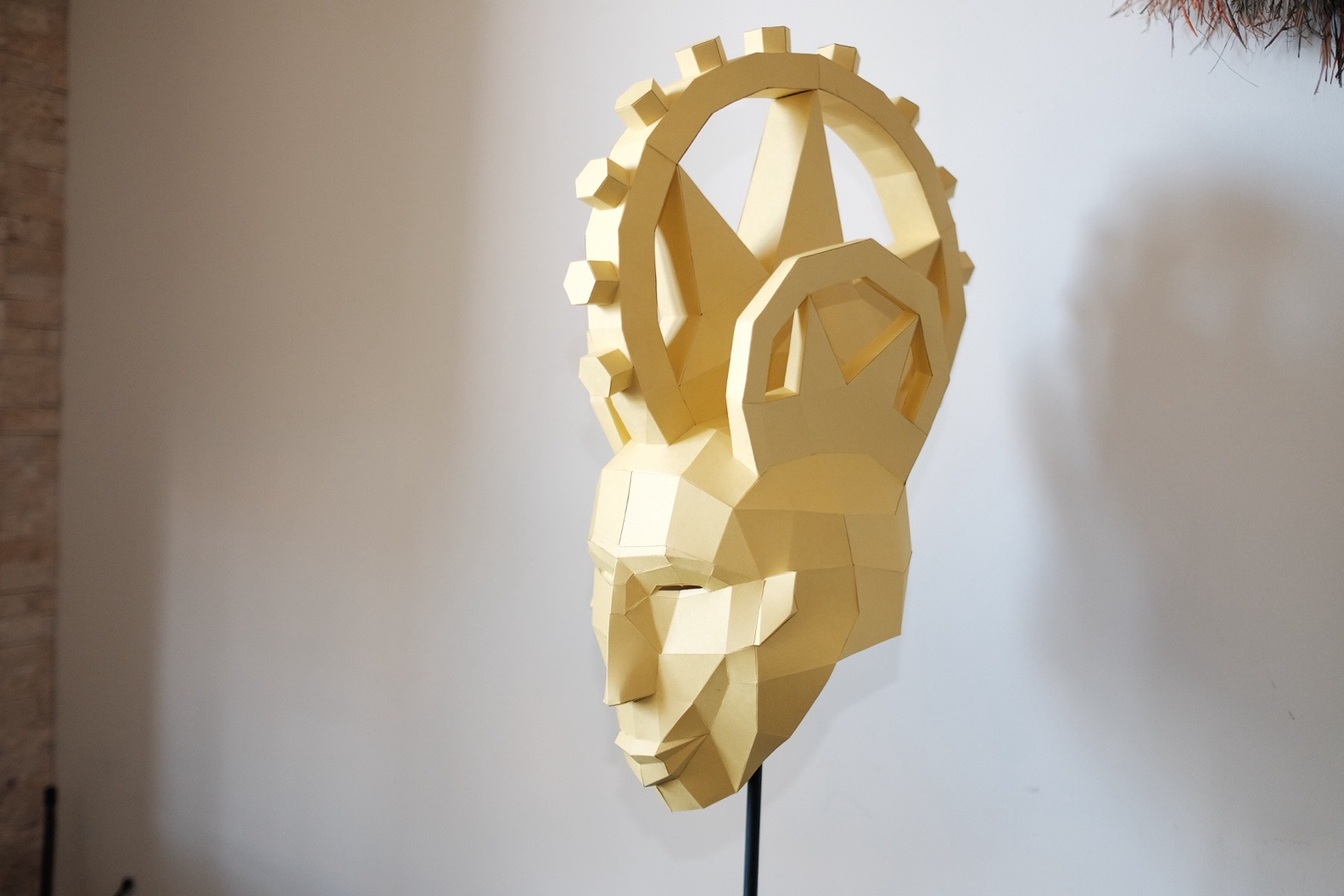 Gold geometric contemporary mask displayed as a freestanding object