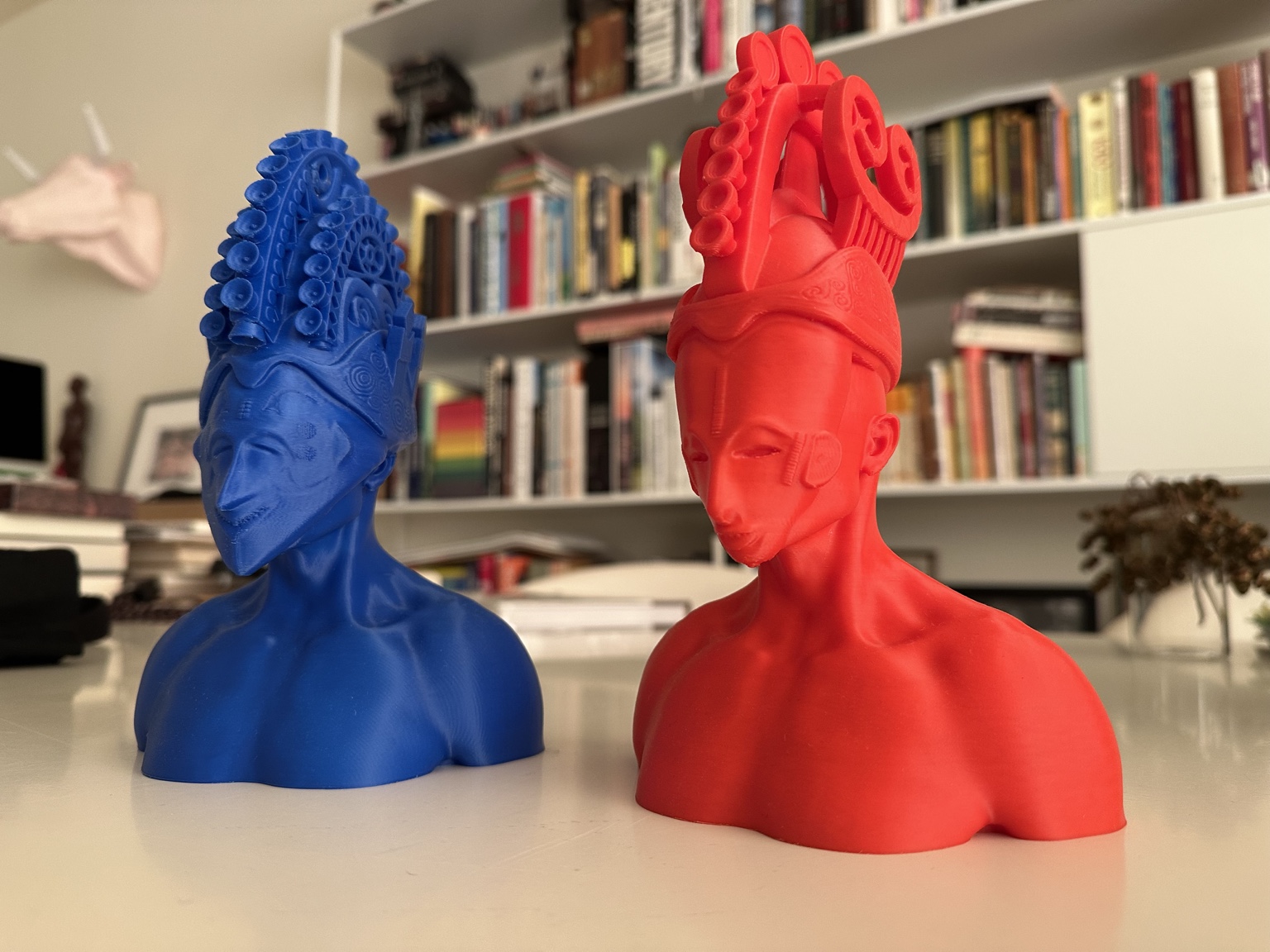 Red and blue contemporary mask-inspired figures in a library
