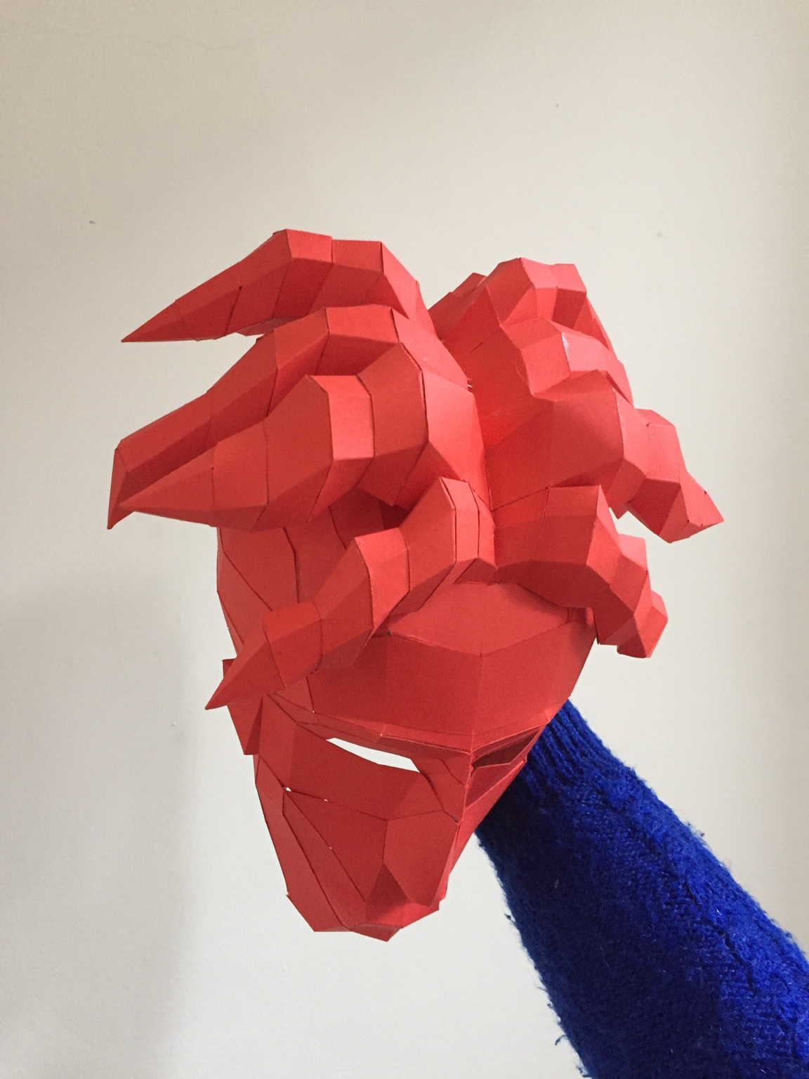 A red geometric hand-built mask prototype