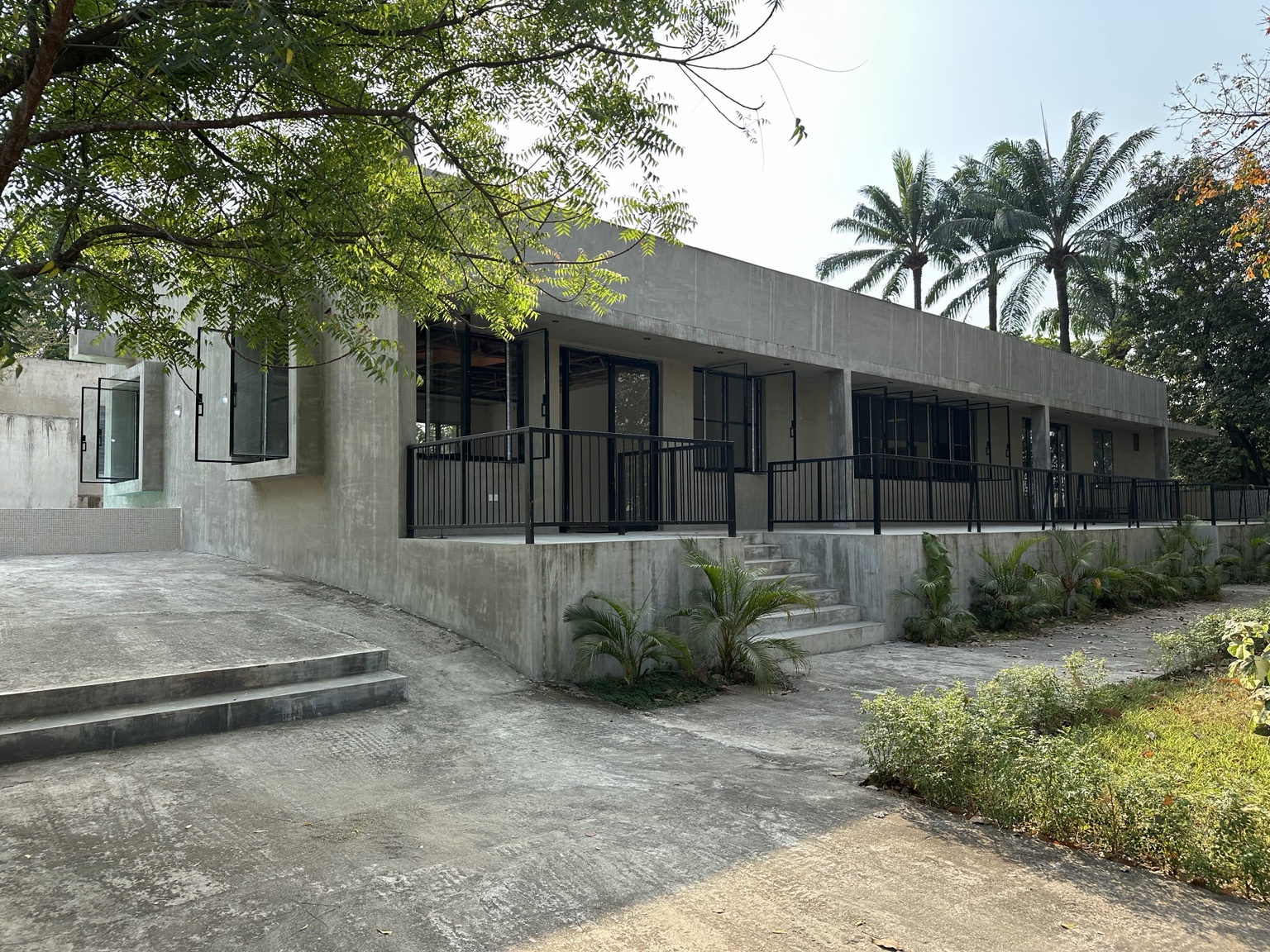 Long veranda of Okpara House surrounded by mature trees in Oraifite